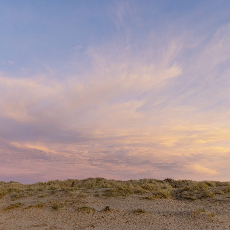 Purple and pinks sunset on Ainsdale beach north west coast England showing the sand dunes and grasses