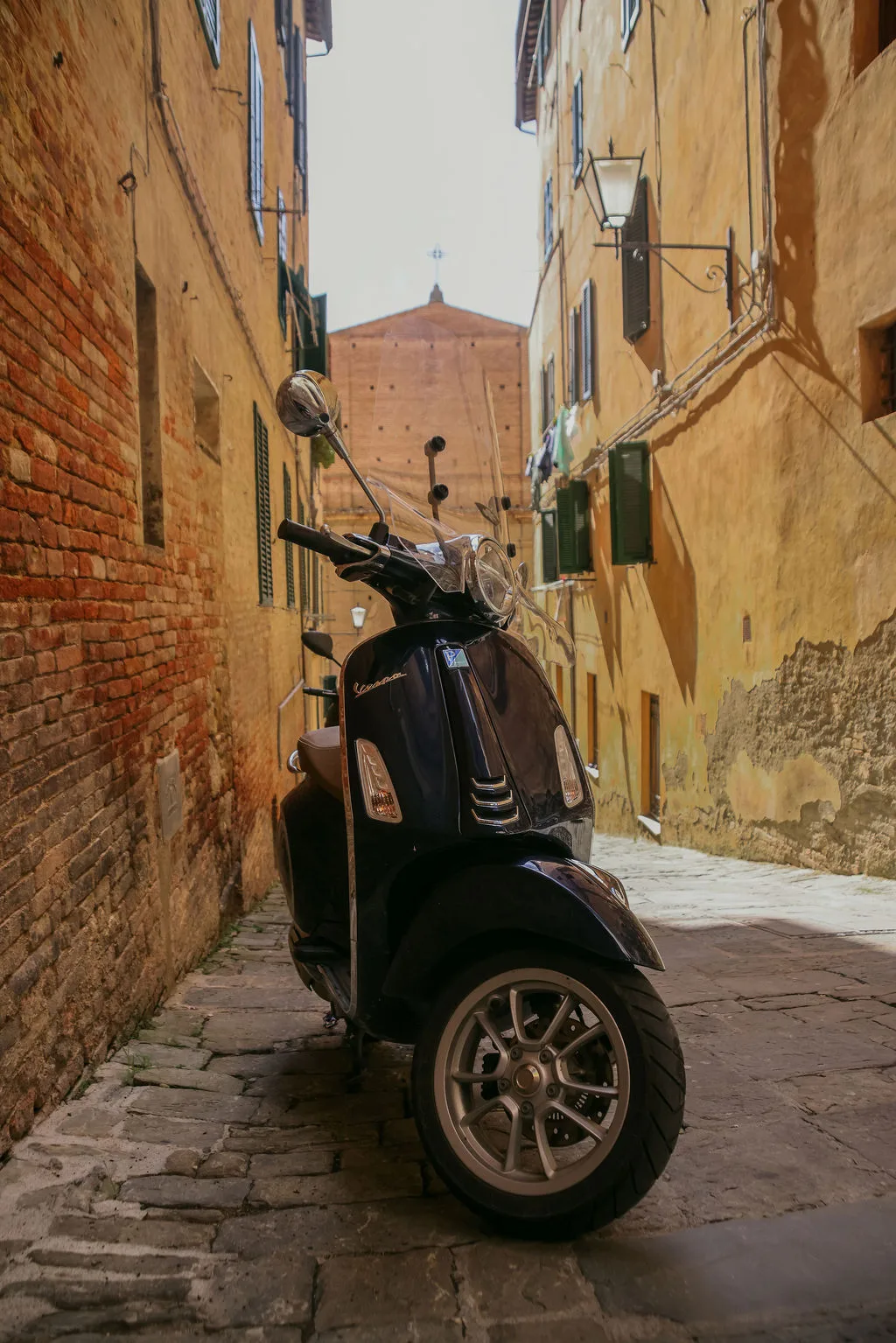 A scooter on the golden streets on Siena Italy